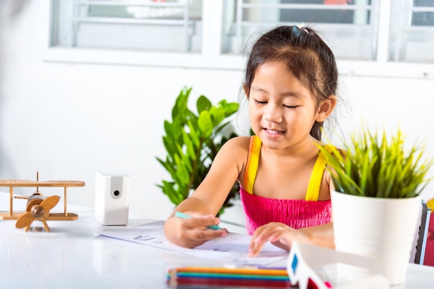 Kind klein meisje tekenfilm op papier voordat de kleur wordt geverfd