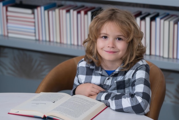 Kind leest een rood boek in de bibliotheek Weinig student op schoolbibliotheek