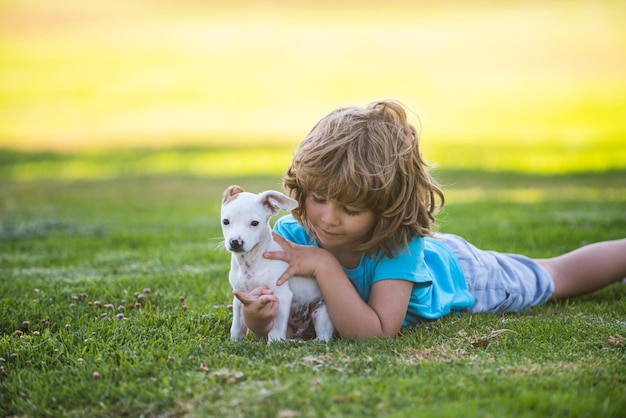 Kind lief omhelst zijn huisdier hondje jongen met hond ontspannen op de natuur