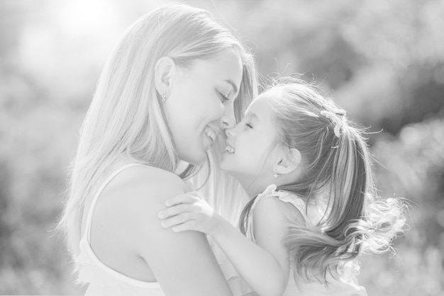 Kind liefde gelukkige lachende moeder met haar dochtertje op zonsondergang achtergrond gelukkige moeder knuffelen h