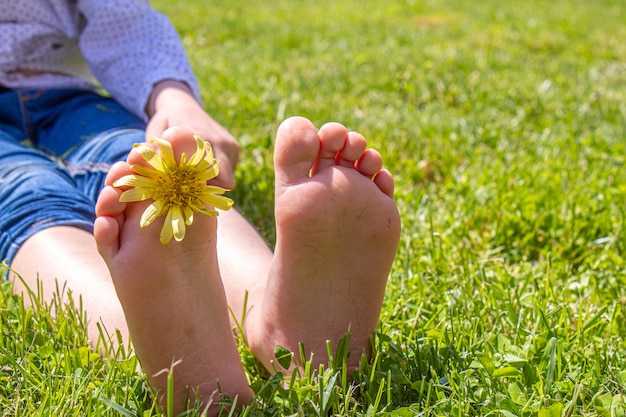 Kind liggend op groen gras. Kid plezier buiten in het voorjaarspark. Selectieve aandacht. mensen