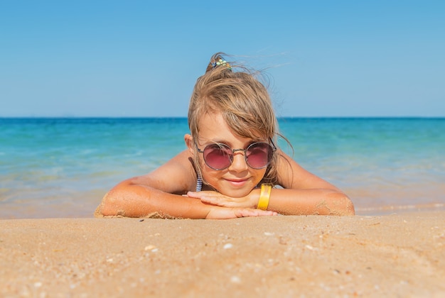 Kind ligt in het zand op het strand