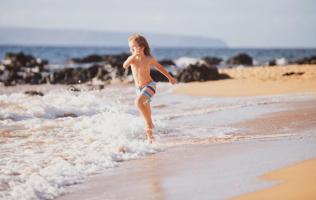 Kind loopt door water dicht bij de kust langs het zeestrand Een jongen rent langs de zeekust Rust o...