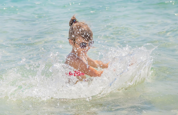 Kind maakt spray op de zee