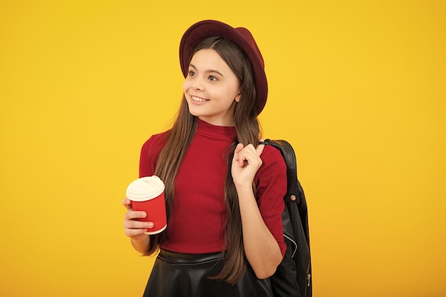 Kind meisje 12 13 14 jaar oud met afhaal kopje cappuccino koffie of thee Tiener met afhaalmaaltijden mok op gele achtergrond ochtend drankje drank Gelukkig tiener portret Glimlachend meisje