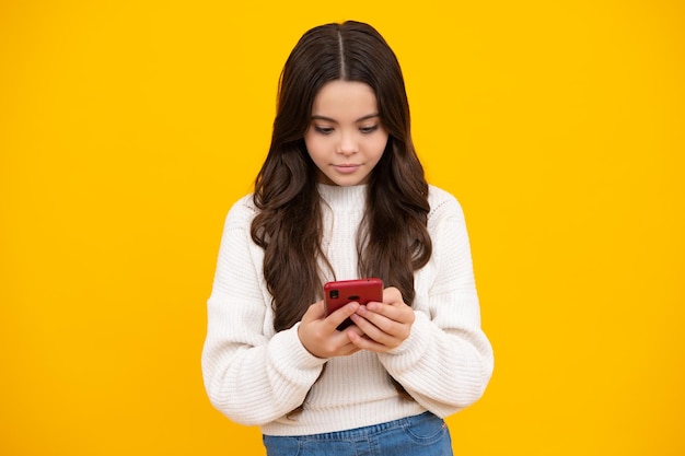 Kind meisje 12 13 14 jaar oud met smartphone Hipster tiener meisje typt sms-bericht op mobiele telefoon geniet van mobiele app Kid houdt smartphone sms'en in online sociale media Internetverslaving