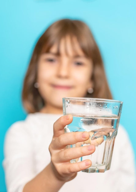 Kind meisje drinkt water uit een glas selectieve aandacht