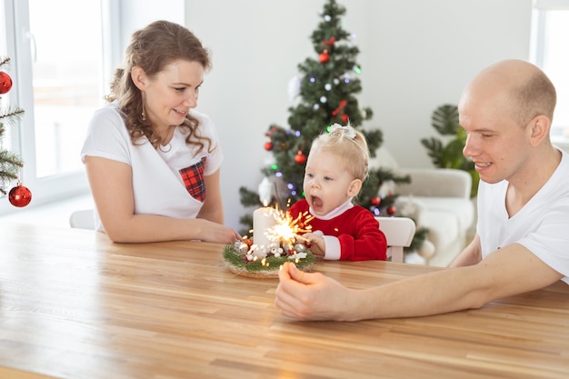 Kind meisje gekleed in kerstjurk met cochleaire implantaten plezier thuis kerstboom achtergrond diversiteit en gehoorapparaat en innovatieve technologieën voor de behandeling van doofheid