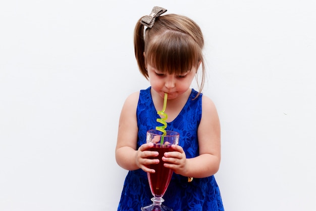 Kind meisje kruisbes verfrissing drinken met leuk stro, witte achtergrond