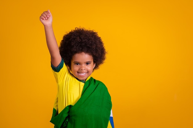 Kind meisje Latijns-Amerikaanse juichen voor Brazilië op WK 2022 patriot nationalist zwaaien braziliaanse vlag juichen en springen symbool van geluk vreugde en feest met vlag van brazilië