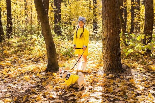 Kind meisje met hond buiten. Kid met huisdier in de herfst. Jack russell Terriër pup.