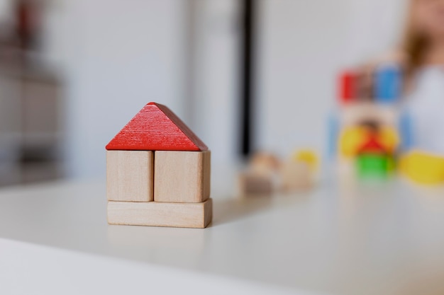 Foto kind meisje spelen met kleurrijke houten speelgoed bouwstenen. klein kind bouwt toren of huis thuis of kinderopvang. bouwblok voor baby of peuter. knoeien in de speelkamer van de kleuterschool.