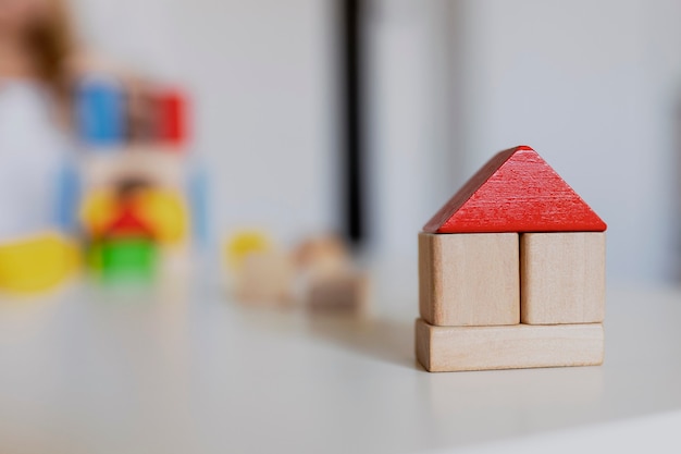 Kind meisje spelen met kleurrijke houten speelgoed bouwstenen. Klein kind bouwt toren of huis thuis of kinderopvang. Bouwblok voor baby of peuter. Knoeien in de speelkamer van de kleuterschool.