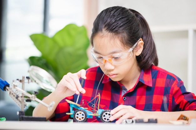 Kind meisje student bouw robot auto's kind leren programmeren robot voertuigen