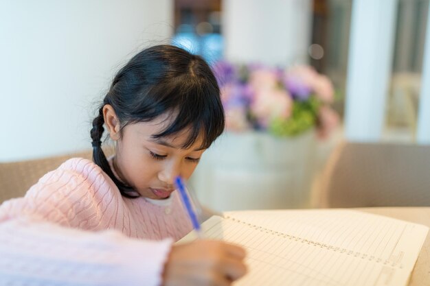 Kind meisje tekent op boek