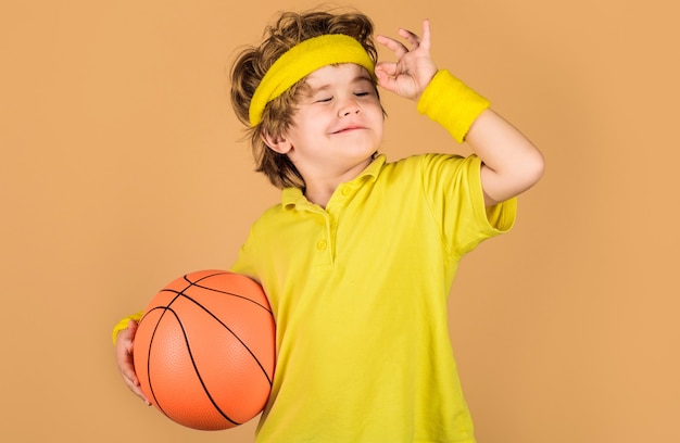 Kind met basketbal. Sportieve jongen in sportkleding met bal. Sporten voor kinderen. Sport actief.