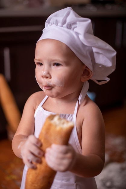 kind met brood in zijn handen verkleed als kok