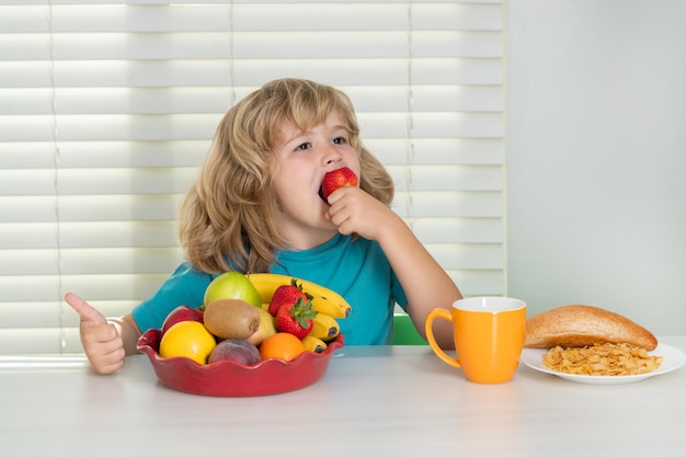 Kind met de vruchten van de aardbeizomer schoolkind die ontbijt eten vóór schoolportret van weinig te