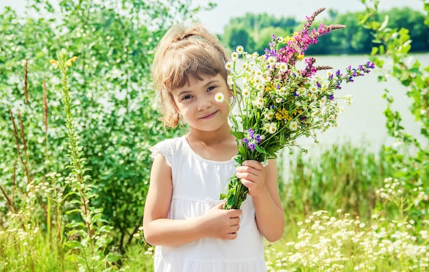 Kind met een boeket van wilde bloemen. Selectieve aandacht. natuur.