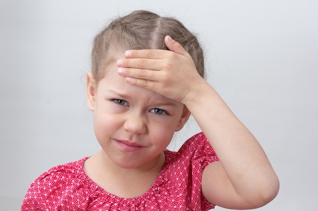 Foto kind met hoofdpijn met hand op voorhoofd