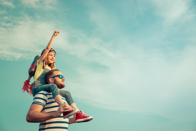 Kind met jetpack doen alsof ze superheld zijn Kind spelen met vader in de zomer Gelukkige vader en zoon buitenshuis Succes leider en winnaar concept