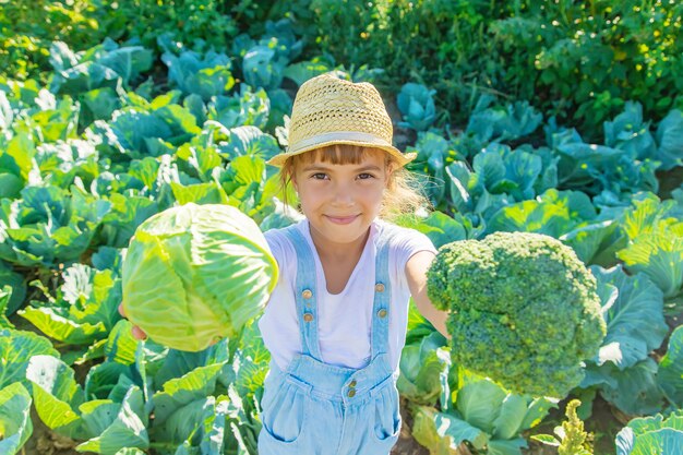 Kind met kool en broccoli in de handen. Selectieve aandacht.