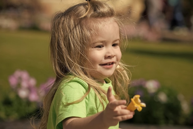 Kind met lachend gezicht met gele bloem