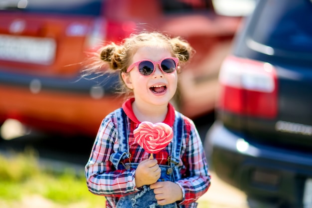 Kind met Lollipop op een stokje in zijn handen op de achtergrond van de muur