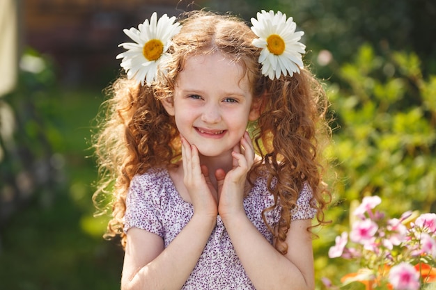 Kind met madeliefjeogen op groen gras in een zomerpark