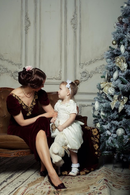 Kind met moeder die in de buurt van de kerstboom ontvangt