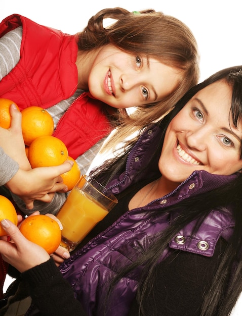 Kind met moeder met sinaasappels en sap