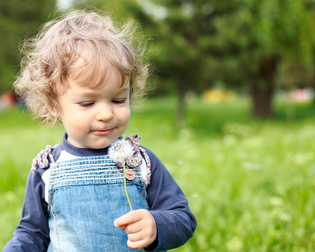 Kind met paardebloem in zomerpark