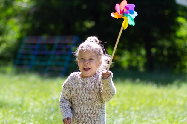 Kind met Pinwheel in het zomerpark camera kijken