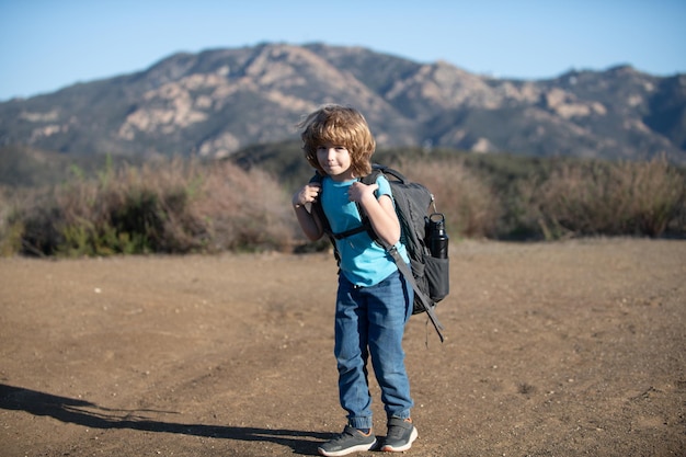 Kind met rugzak wandelen in schilderachtige bergen jongenskind lokale toerist gaat op een lokale wandeling