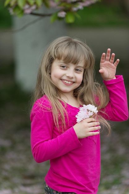 Kind met sakura bloemen, lente. Kindglimlach met kersenbloesem, schoonheid.