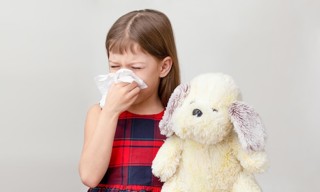 Kind met servet op neus met allergie voor speelgoed Kaukasisch klein meisje van jaren op witte backgro