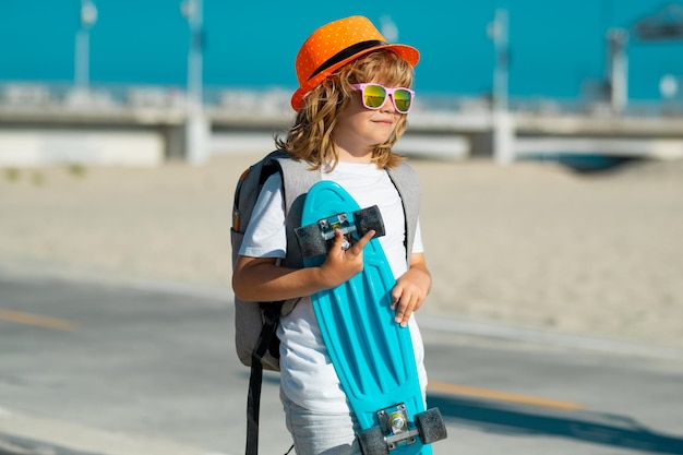 Kind met skateboard Kind houdt skatebord vast Gezonde sport en activiteit voor schoolkinderen in de zomer Sportplezier