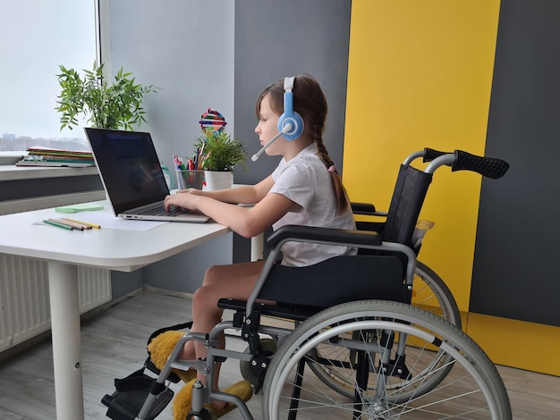 Kind met speciale behoeften op rolstoel gelukkige tijd om laptop thuis te gebruiken en op afstand te studeren