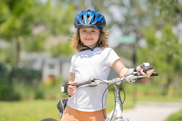 Kind op een fiets in het zomerpark, kinderen leren fietsen op een oprit buiten kid ri