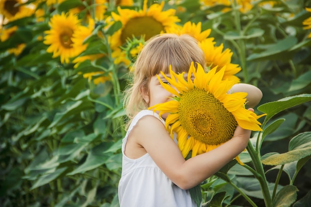 Kind op het gebied van zonnebloemen is een kleine boer. selectieve aandacht.