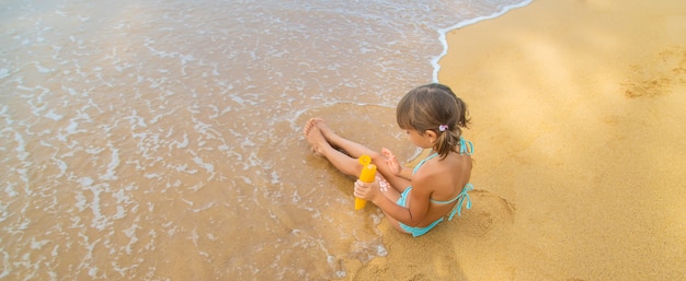 Kind op het strand met zonnebrandcrème