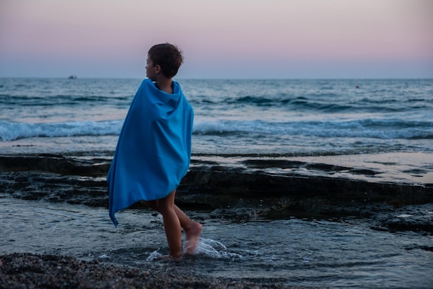 Kind op het strand tijdens zonsondergang