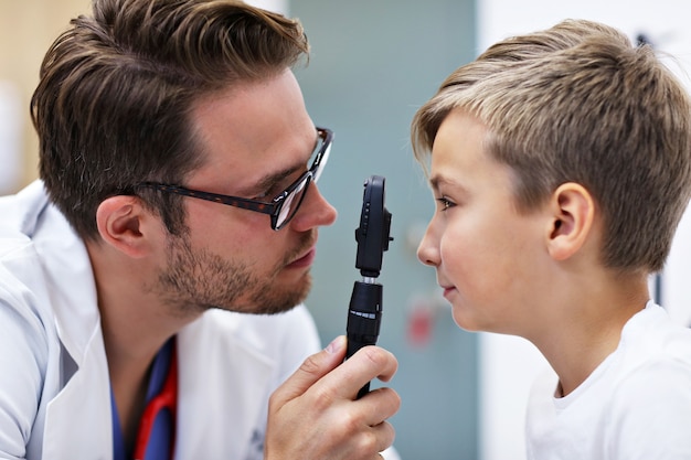 kind optometrie mannelijke optometrist opticien arts onderzoekt het gezichtsvermogen van kleine jongen