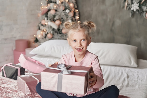 Kind pyjama dragen en kerstcadeau openen