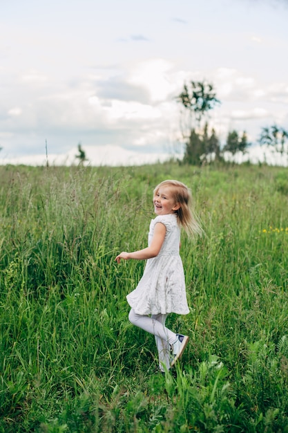 Kind rent en springt op een pad in het veld