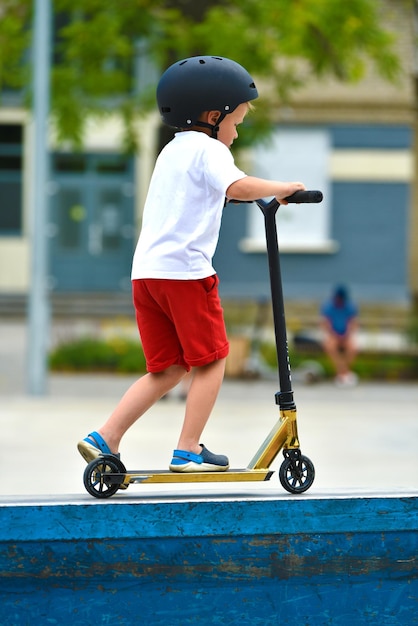 kind rijdt op een Kick-scooter. speeltuin voor het rijden op Kick scooter. skatepark. jonge beginnende atleet