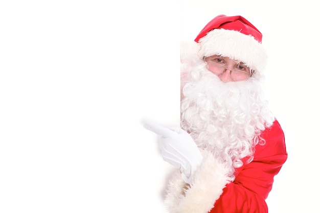 Kind Santa Claus pointing in white blank sign, isolated on white background.