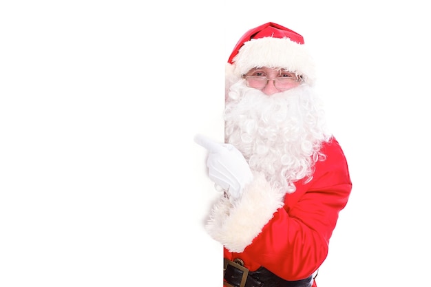 Kind Santa Claus pointing in white blank sign, isolated on white background.