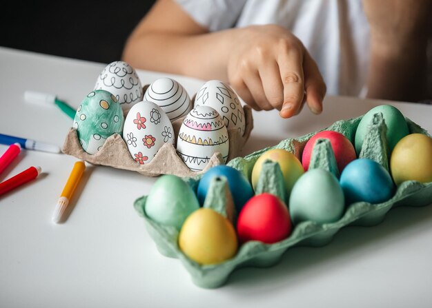 Foto kind schildert eieren met verschillende kleuren