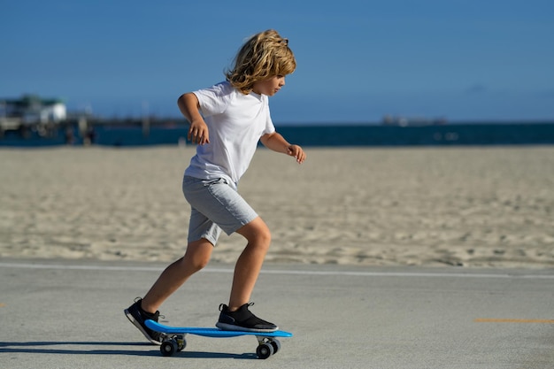 Kind skateboarden in het park in de stad Kid jongen genieten en plezier buitenshuis levensstijl Kind beoefenen van extreme sport longboard schaatsen op zomer weg